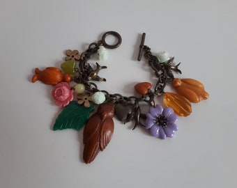 Vintage antiqued brass color charm bracelet with large flower bird heart plastic charms