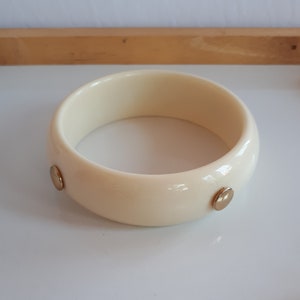 Cream plastic resin domed bangle bracelet with gold metal studs