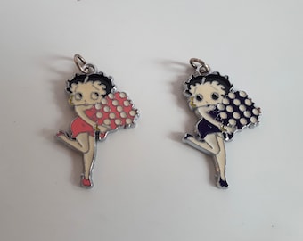 May include: Two silver charm pendants featuring a cartoon character holding a bouquet of flowers. One charm has red flowers with white polka dots and the other has purple flowers with white polka dots.