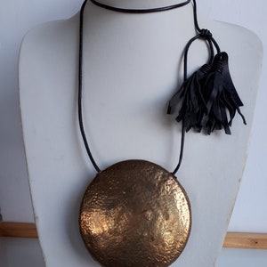 Unique unisex RUNWAY Vintage signed NEW MAN modernist Boho hollow disc brass pendant necklace black leather cord 2 tassels
