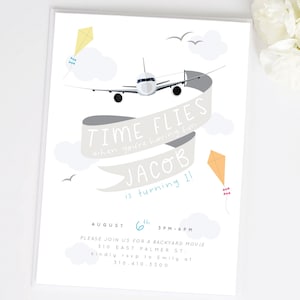 Puede incluir: Un avión blanco vuela por un cielo azul con nubes y cometas. El texto "TIME FLIES when you're having fun" está en una pancarta. El texto "JACOB is turning 11" está debajo de la pancarta. El texto "AUGUST 6th 3PM-6PM" está en la parte inferior de la invitación. El texto "PLEASE JOIN US FOR A BACKYARD MOVIE 310 EAST PALMER ST. kindly rsvp to Emily at 310.410.3300" está debajo de la fecha y la hora.
