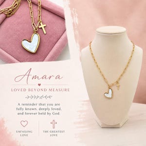 May include: A gold-toned chain necklace featuring a heart-shaped pendant with a white pearlescent inlay and a small cross charm. The text on the display reads: Amara, LOVED BEYOND MEASURE, A reminder that you are fully known, deeply loved, and forever held by God.