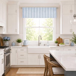 May include: A window valance featuring a light blue and white vertical striped pattern. The fabric is hung on a silver curtain rod above a kitchen sink, displaying a clean, straight-edged design that covers the top portion of the window frame.