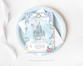Puede incluir: Una invitación azul y dorada con temática de Cenicienta. La invitación presenta una ilustración de acuarela del castillo de Cenicienta, calabazas, un zapato de cristal y un reloj. El texto de la invitación dice "Brinley's Third Birthday" e incluye la fecha, la hora y la ubicación de la fiesta.