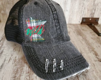 Peut inclure: Un chapeau de camionneur noir et gris délavé avec un dos en maille noire. Le chapeau présente une silhouette du Minnesota en plaid avec le mot "Wild" en lettres vertes et rouges.