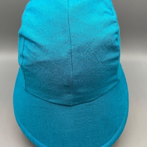 May include: A turquoise baseball cap with a curved brim. The cap is made of a soft fabric and has a structured crown. The cap is a solid color and has a simple, classic design.