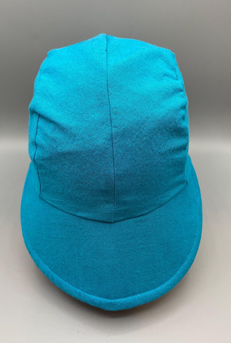 May include: A turquoise baseball cap with a curved brim. The cap is made of a soft fabric and has a structured crown. The cap is a solid color and has a simple, classic design.