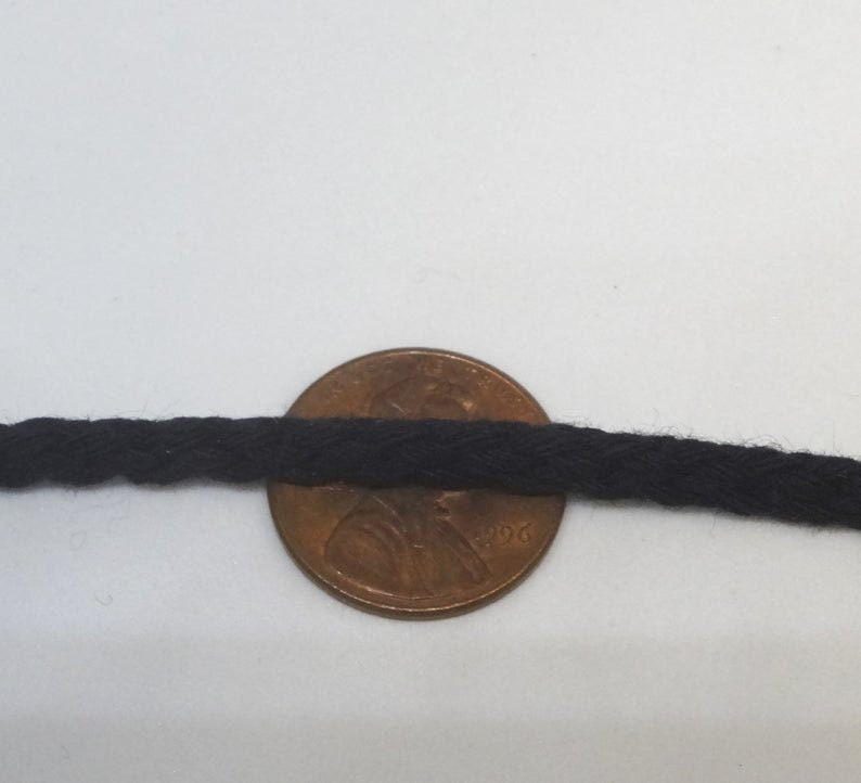 May include: Black cotton cord, approximately the size of a US penny.