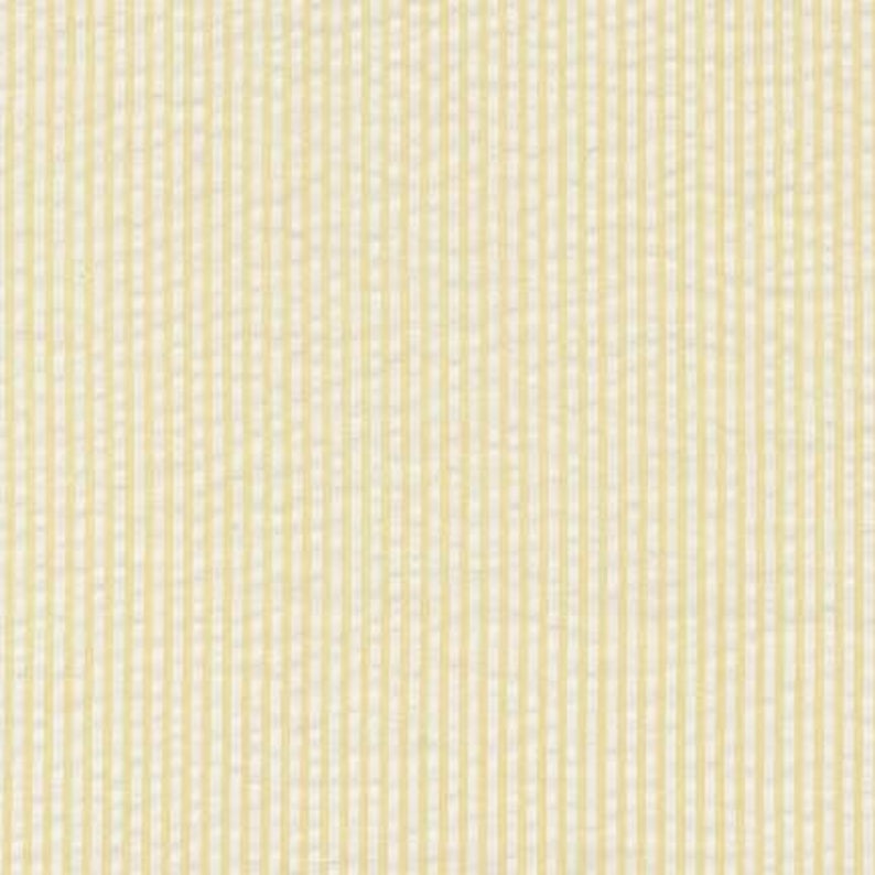 May include: A close-up of a yellow and white striped fabric. The fabric has a subtle texture and a slightly off-white background.