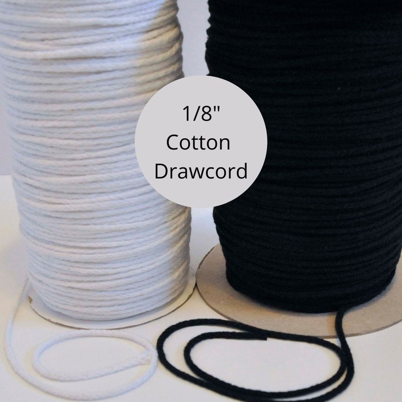 May include: Two spools of 1/8 inch cotton drawcord, one white and one black. The spools are on a white surface with a small length of each color cord in front of them.