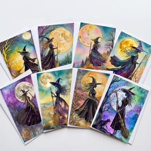 May include: A collection of eight rectangular greeting cards featuring watercolor illustrations of witches in pointed hats holding broomsticks against large, glowing full moons. The artwork displays vibrant purple, blue, and yellow color palettes.