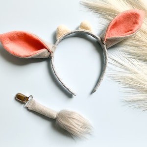 May include: A gray headband with two pink felt ears and a white felt accent on each ear. A gray felt tail with a silver clip is also included.