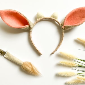 May include: A brown headband with two peach felt ears and two white felt horns. A brown and beige tail with a clip is also included.