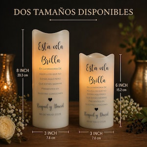May include: Two white LED candles with Spanish text, "Esta vela Brilla," and custom details. The larger candle is 20.3 cm tall and 7.6 cm wide, the smaller is 15.2 cm tall and 7.6 cm wide. The text reads "DOS TAMA&Ntilde;OS DISPONIBLES."