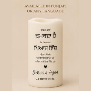 Peut inclure: Une bougie blanche avec du texte en pendjabi et en anglais. La bougie porte les mots "IN LOVING" et "Simran & Arjun" avec la date "24 ao&ucirc;t 2026". Le haut de la bougie a un design ondul&eacute;.