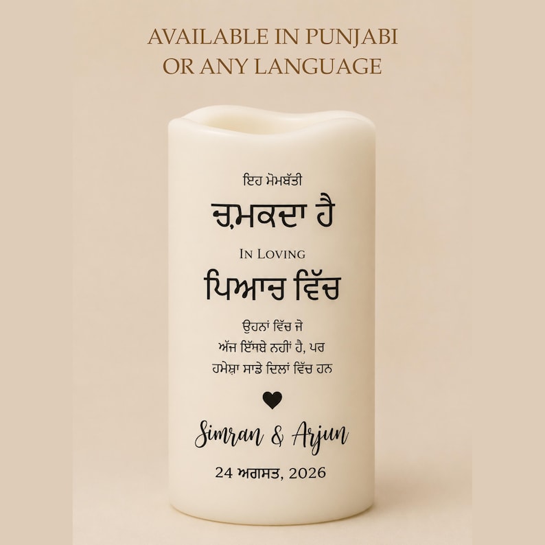 Peut inclure: Une bougie blanche avec du texte en pendjabi et en anglais. La bougie porte les mots "IN LOVING" et "Simran & Arjun" avec la date "24 ao&ucirc;t 2026". Le haut de la bougie a un design ondul&eacute;.