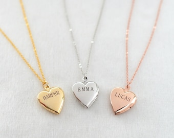 May include: Three heart-shaped lockets on fine chains. One is gold with "HARPER" engraved, another is silver with "EMMA", and the third is rose gold with "LUCAS". The lockets are shown against a soft, neutral background.