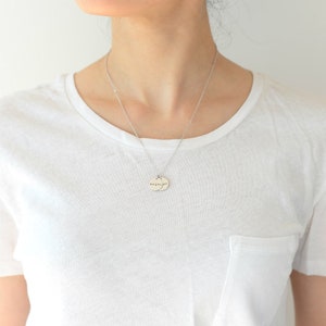 Op de afbeelding: Een zilveren ketting met twee ronde hangers. De hangers zijn gegraveerd met het woord "Megan" op de ene en "Joy" op de andere.