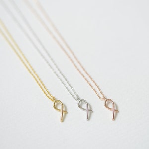 May include: Three delicate necklaces with a simple infinity symbol pendant. The necklaces are available in gold, silver, and rose gold.