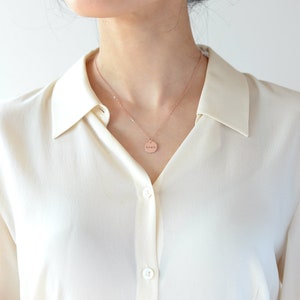 Op de afbeelding: Een ketting van ros&eacute;goud met een ronde hanger waarop "noah" staat.