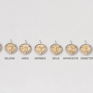 May include: Eight gold-colored pendants with different Greek mythological figures and the Parthenon, each with a silver-colored ring around the edge. The pendants are labeled with their names: Helios, Selene, Ares, Hermes, Zeus, Aphrodite, Demeter, and Parthenon.