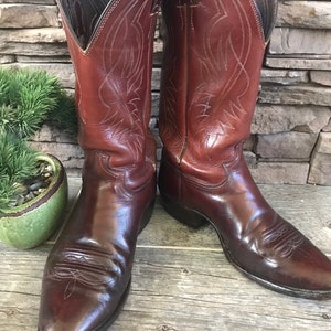 May include: A pair of brown leather cowboy boots with intricate stitching and pointed toes.