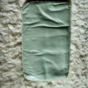 May include: A sage green fabric sheet wrapped in plastic packaging.