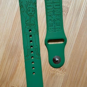 Anime hunter themed engraved design on a silicone watch band compatible with Apple Watch and Galaxy Watch .