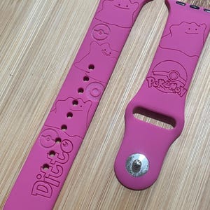 Anime themed blob like character engraved design on a silicone watch band compatible with Apple Watch and Galaxy Watch .