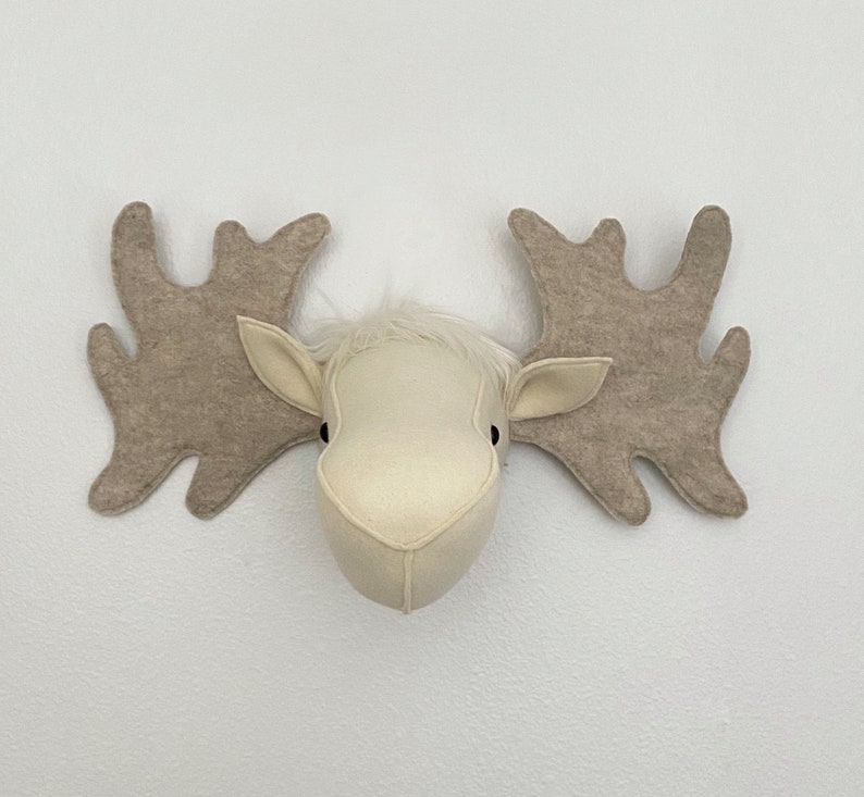 May include: A white felt moose head with brown felt antlers. The moose head is a wall decoration.
