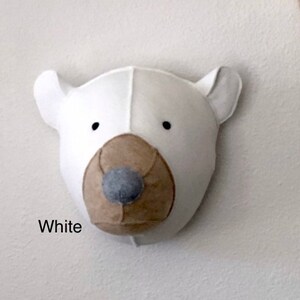 May include: White felt polar bear head wall decor with a brown felt nose and black eyes.