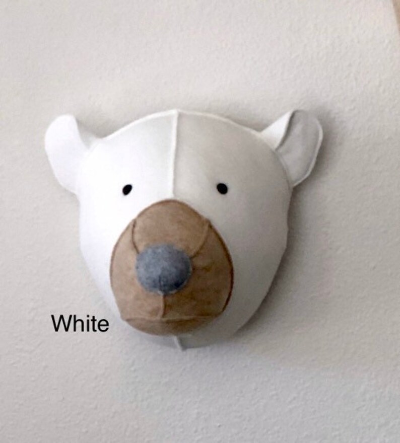 May include: White felt polar bear head wall decor with a brown felt nose and black eyes.