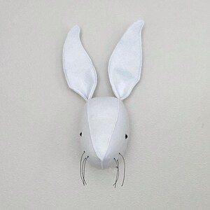 May include: White felt bunny rabbit head wall decor with black felt whiskers.