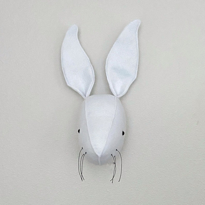 May include: White felt bunny rabbit head wall decor with black felt whiskers.
