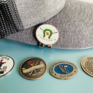 golfball markers and hatclip. vintage and new golfball markers from various golf courses, tournaments, and events. rare golfball markers.