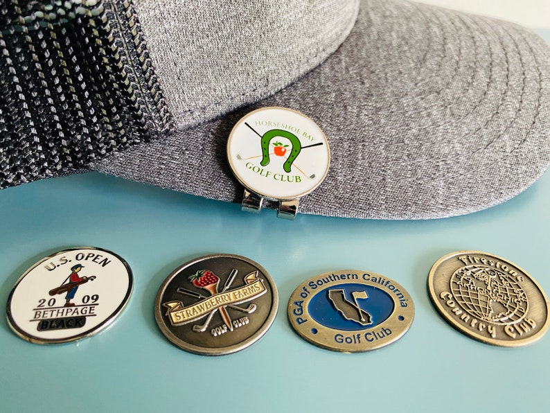 golfball markers and hatclip. vintage and new golfball markers from various golf courses, tournaments, and events. rare golfball markers.