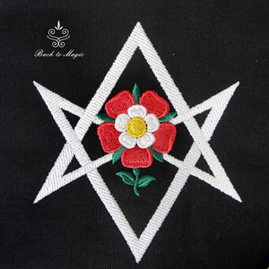 Op de afbeelding: Wit geborduurd pentagram met een rode en witte roos in het midden op een zwarte achtergrond. De tekst "Back to Magic" staat boven het pentagram.