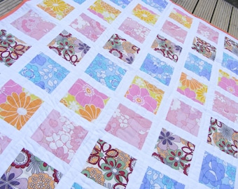 Edredón de cuna de patchwork contemporáneo: cuadrados de tela con motivos florales retro
