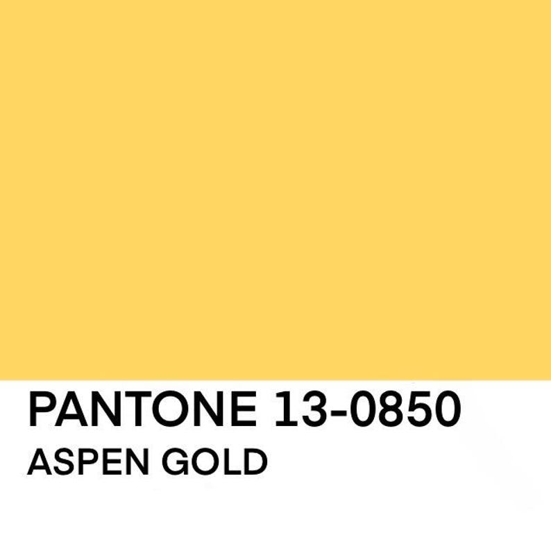 K&ouml;nnte beinhalten: Ein goldgelber Hintergrund mit dem schwarzen Text "PANTONE 13-0850 ASPEN GOLD". Die Farbe ist ein warmes, goldenes Gelb, und der Text ist in einer serifenlosen Schriftart.