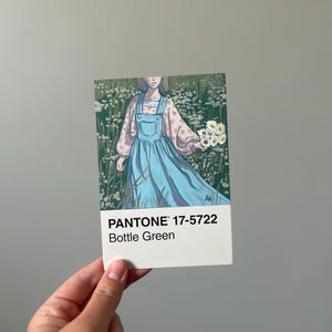 Könnte beinhalten: Eine Karte mit einem Gemälde einer Person in einem blauen Kleid, die Blumen in einem Feld weißer Blumen hält. Die Karte hat den Pantone-Farbcode 17-5722 und den Farbnamen "Bottle Green".