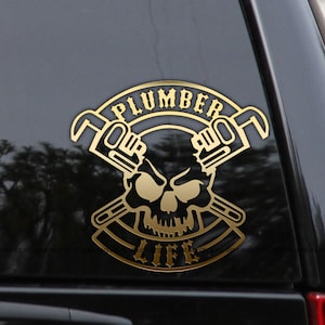 May include: Gold decal sticker with a skull and crossed wrenches. The text "Plumber Life" is written in a banner around the skull.