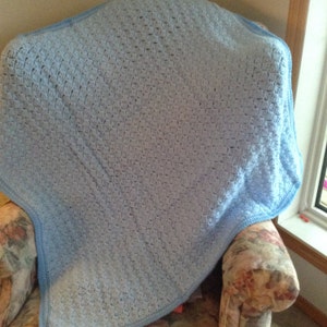 Manta de bebé tejida a crochet con rombos azul pálido