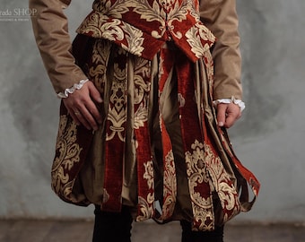 Peut inclure: Un doublet à motifs rouge et or avec une taille haute et une jupe plissée. Le doublet est fait d'un tissu luxueux avec un motif riche et complexe.