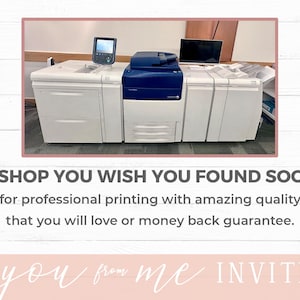 May include: A close-up of three white professional printing machines with blue accents. The machines are in a room with a wooden floor and walls.