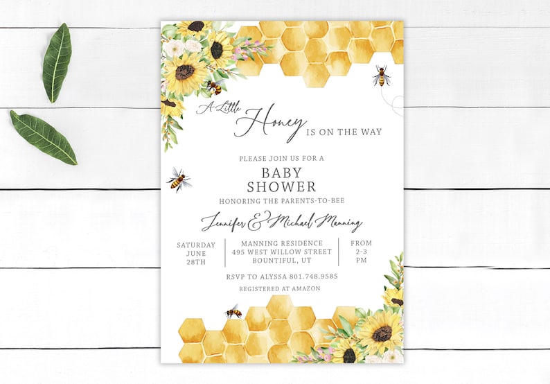 May include: A white baby shower invitation with a honeycomb pattern and sunflowers. The text reads "A Little Honey Is On The Way" and includes the names "Jennifer & Michael Manning".