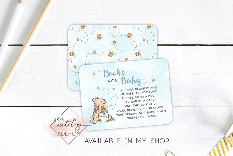 May include: A blue and white baby shower invitation card featuring a Winnie the Pooh illustration and the text "Books for Baby". The card has a bee and honeycomb pattern and the text "A small request and we hope it's not hard. Please bring a book instead of a card. Sign the book and we'll remember and share. Your special gift even when you're not there."
