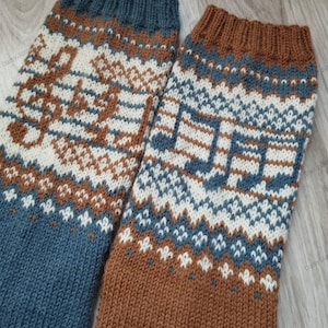 Könnte beinhalten: Ein Paar gestrickte Socken mit einem geometrischen Muster in Braun, Weiß und Blau. Die Socken zeigen Noten im Design.
