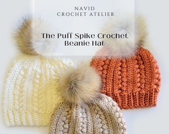 May include: Three crocheted beanies with faux fur pom poms. The beanies are in beige, cream, and orange.