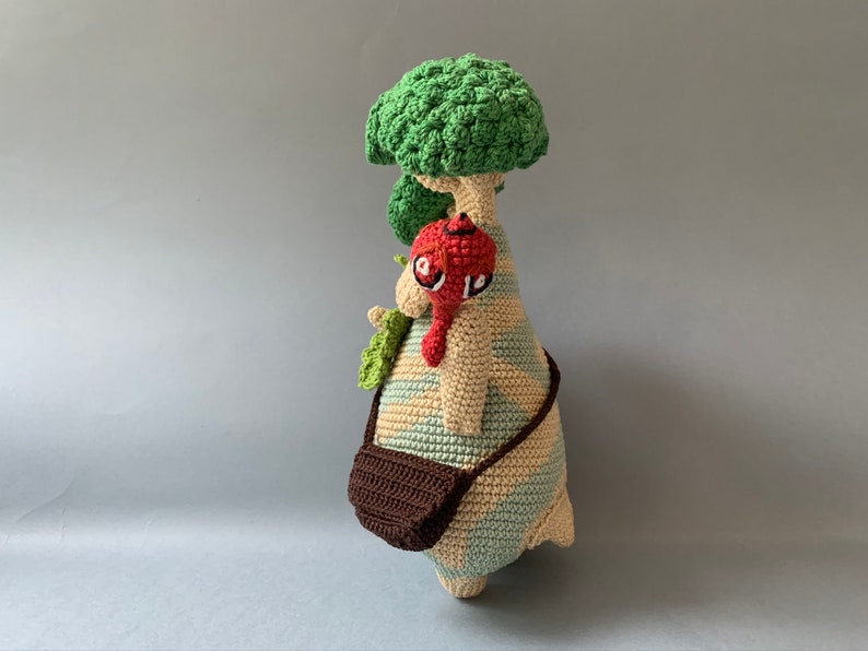 K&ouml;nnte beinhalten: Ein geh&auml;keltes Pl&uuml;schtier in Form eines Baumes mit einem rot-braunen Vogel, der auf einem Ast sitzt. Der Baum hat eine braune Tasche, die an ihm h&auml;ngt.