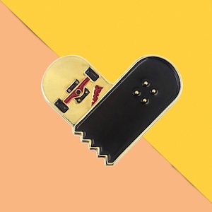 May include: Gold and black enamel pin shaped like a skateboard with a red and white wheel. The pin is a heart shape with the skateboard deck on the left side and the wheels on the right side.